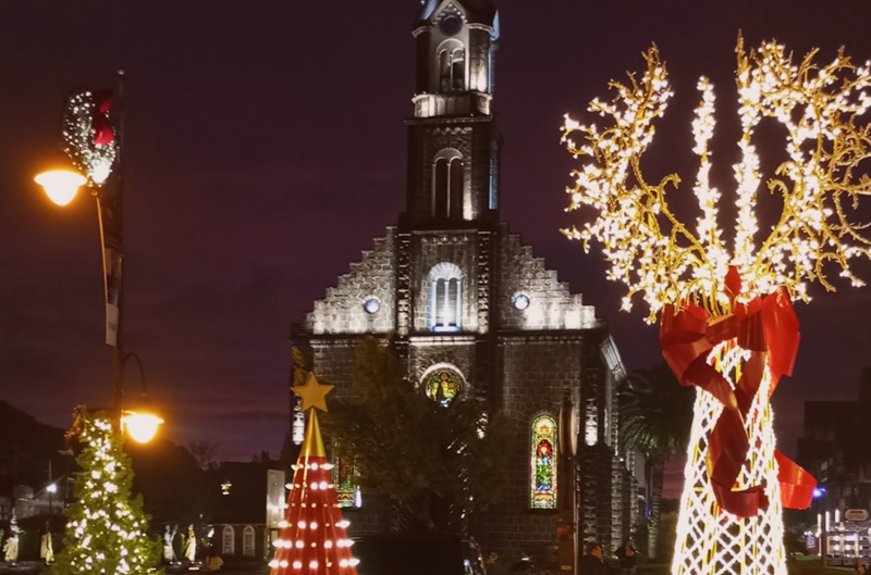 Igreja Matriz de São Pedro iluminada a noite, decoração de natal na rua.