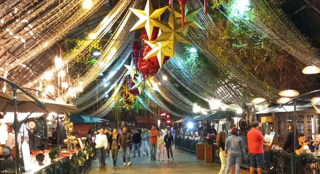 Foto da Rua Coberta de Granado com decoração de natal, pessoas nos restaurantes e caminhando pela rua