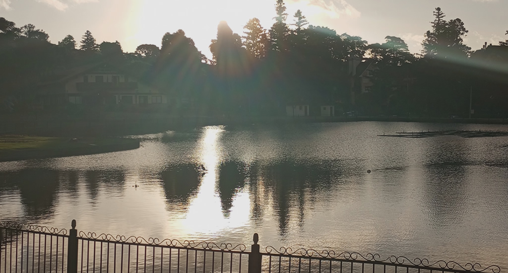 Foto do Lago Joaquina Rita Bier, fim de tarde luz do sol refletindo na água do lago.